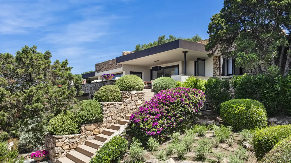 La facciata della villa con la scalinata in pietra e le bouganville