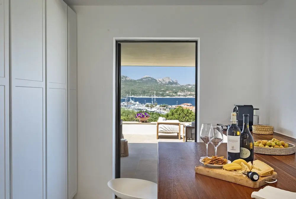 Bottiglie di vino e taglieri su un piano in legno con vista sul porto