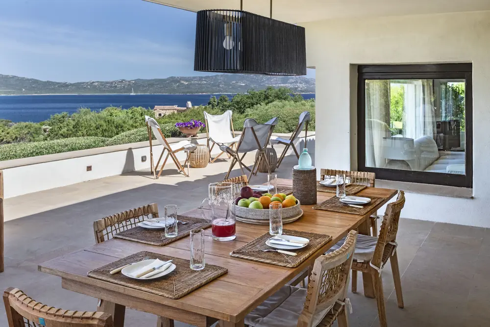 Tavolo apparecchiato in terrazza con vista sul golfo