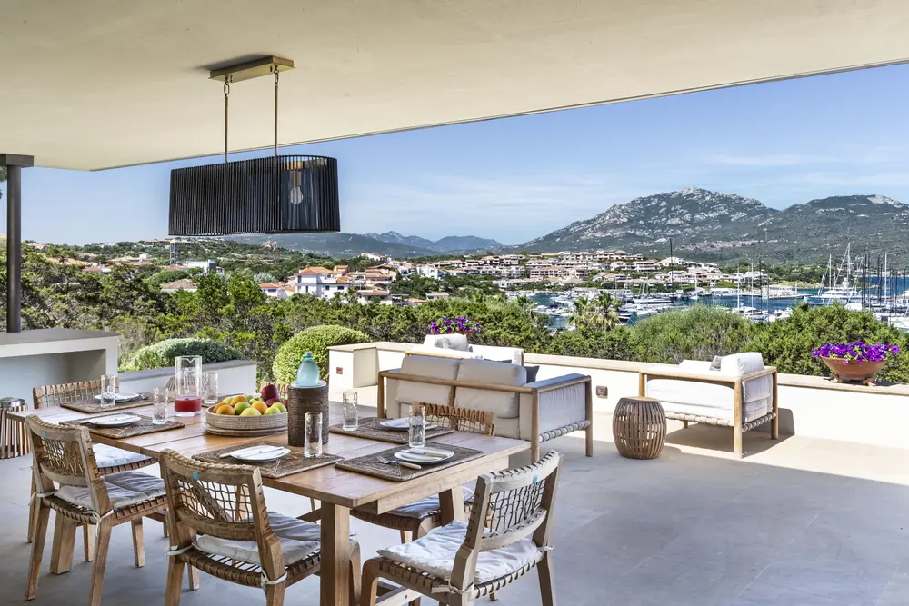 Il grande tavolo conviviale in terrazza, apparecchiato con vista sul porto